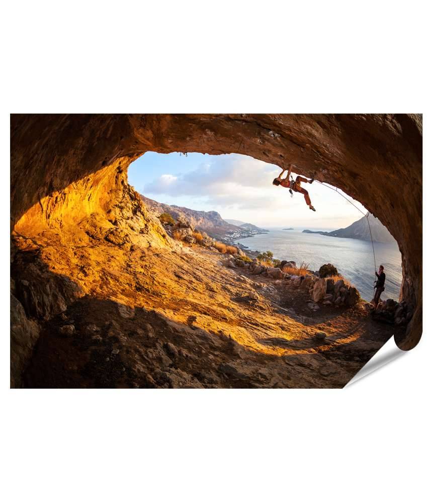 Islandburner XXL Premium Poster Junge Frau klettert in Höhle mit atemberaubender Aussicht im Hintergrund Valentinstagsangebot
