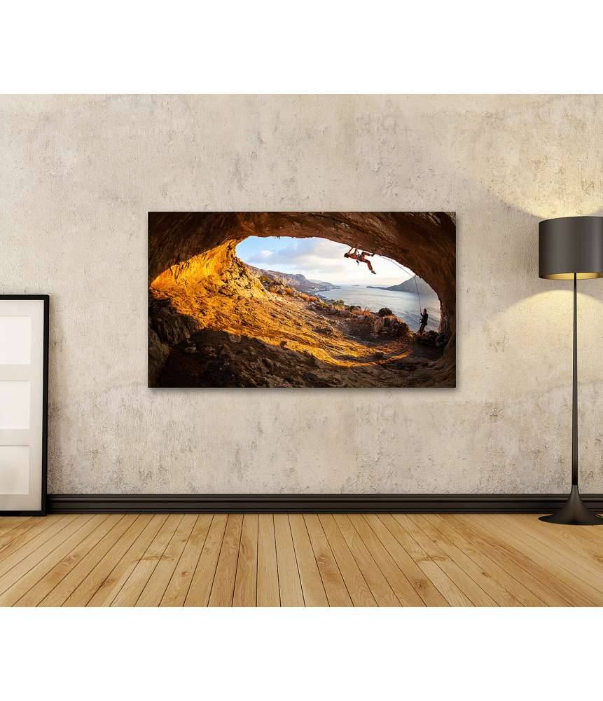 Islandburner Bild auf Leinwand Junge Frau klettert in Höhle mit atemberaubender Aussicht im Hintergrund Jubiläumsangebot